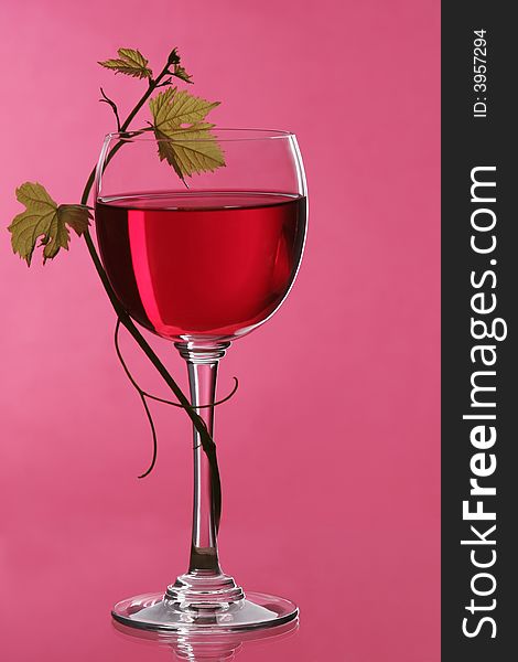 A glass of red wine grape to grape leaf