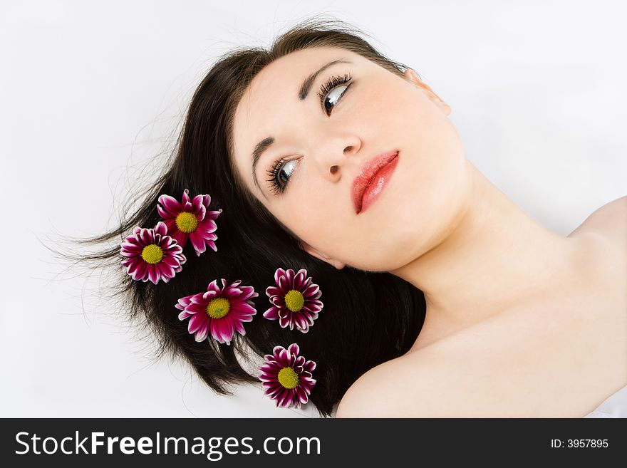 Spa young woman with flower chrysanthemum on gray