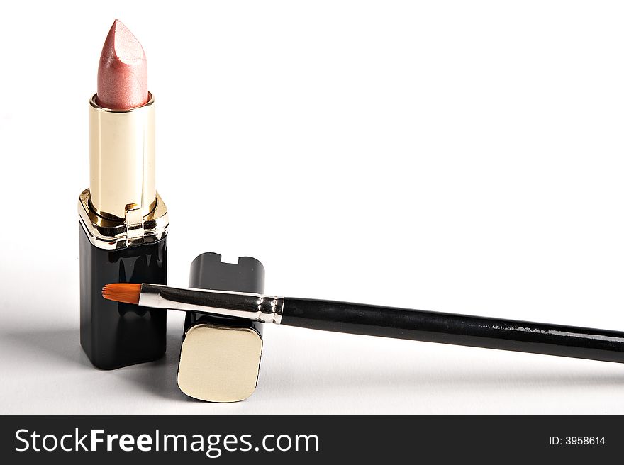 Lipstick and brush on the white background