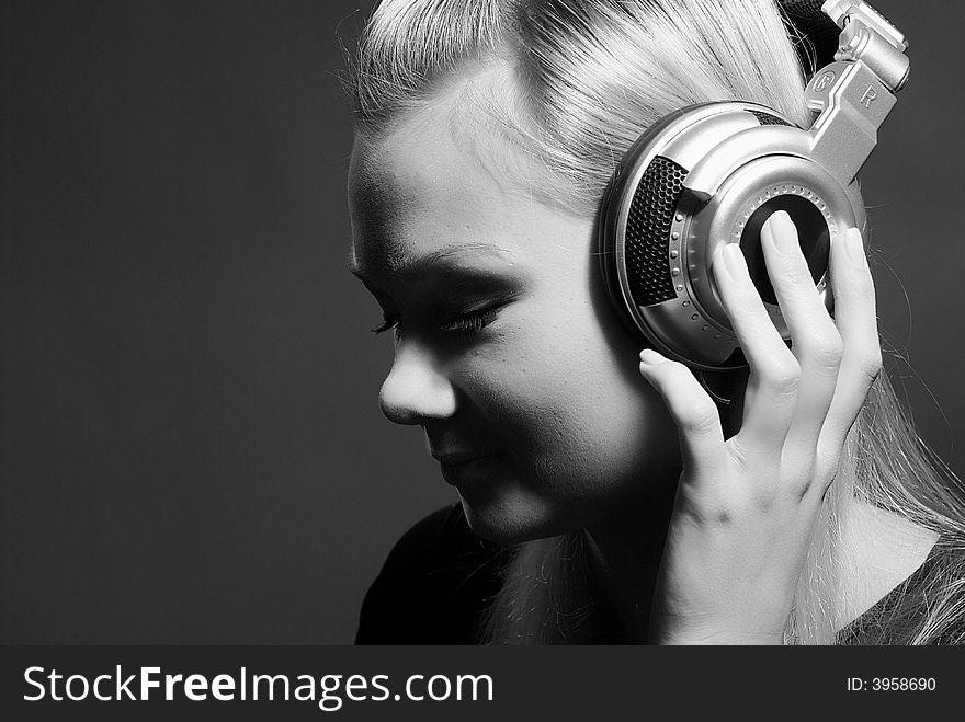 The beautiful girl with headphones on a grey background. The beautiful girl with headphones on a grey background