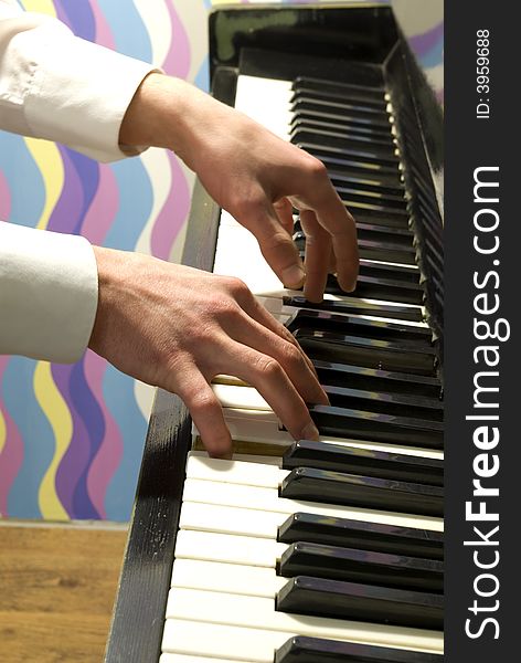 A closeup of a pair of hands playing a piano.