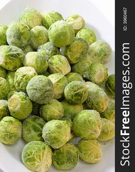 Frozen Brussel Sprouts in a bowl on bright background