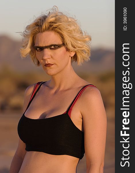 Female science fiction model in a desolate location with dark eye makeup. Female science fiction model in a desolate location with dark eye makeup.