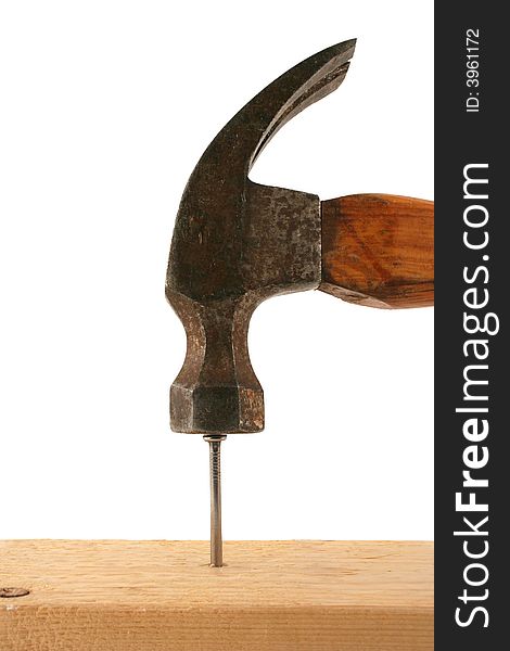 A hammer pounding a nail in wood. A hammer pounding a nail in wood