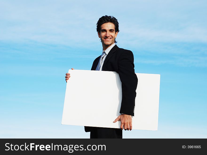 Confident and successful businessman is holding a blank board. Confident and successful businessman is holding a blank board