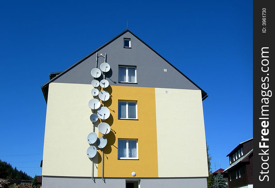 House with many broadcasing satellite recievers on the wall. House with many broadcasing satellite recievers on the wall
