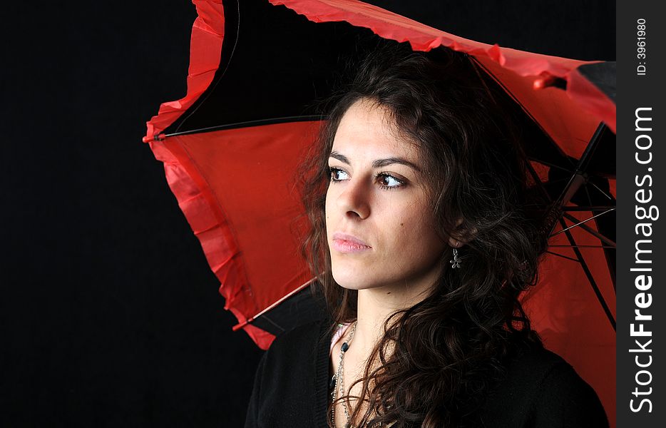 Beautiful brunette with umbrella on black background