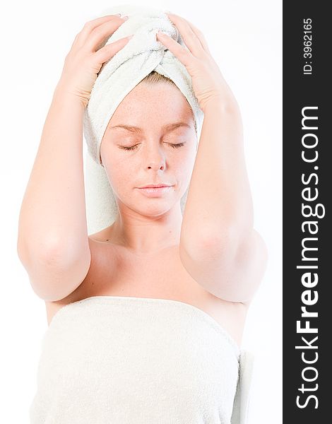 Studio portrait of a spa girl holding her towel on her head. Studio portrait of a spa girl holding her towel on her head