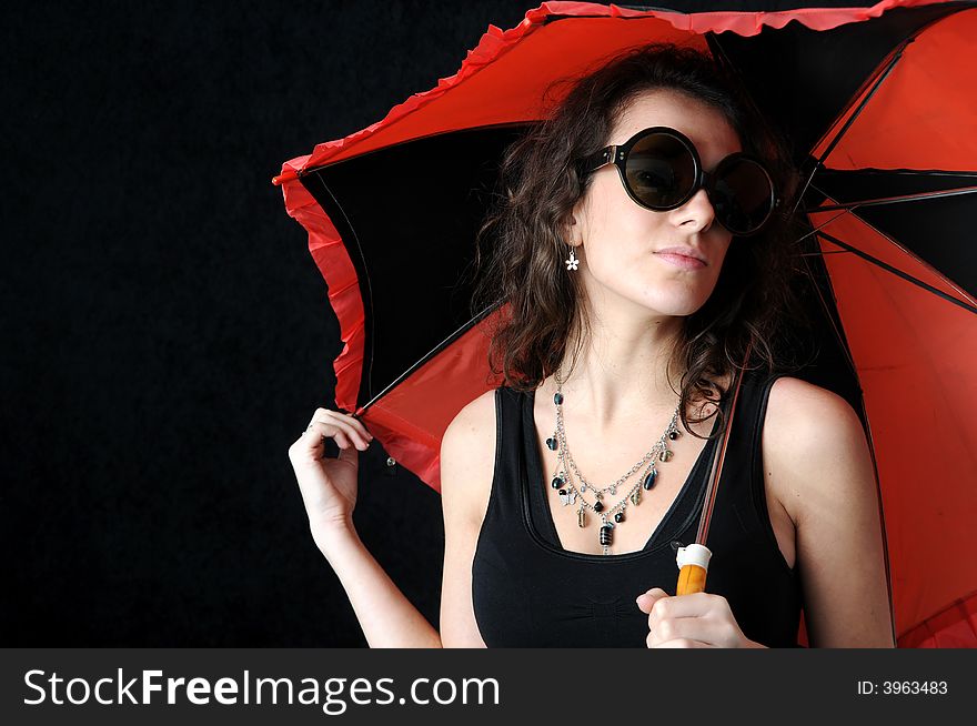 Beautiful brunette with umbrella on black background
