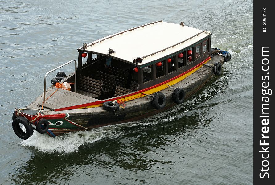 A bumboat travel along a river looking for passengers.