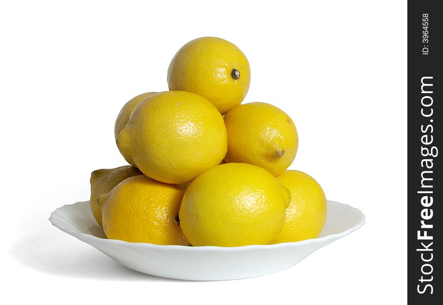 Hill of lemons on a white plate, on a white background