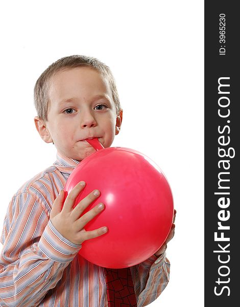 The happy boy inflates a red balloon