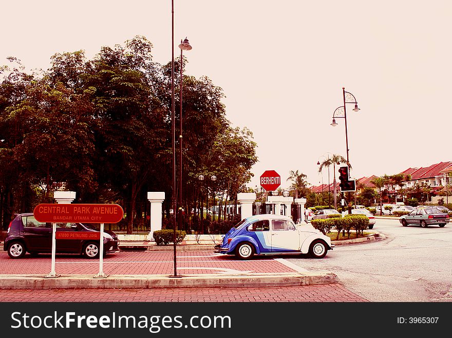 A picture on the contrast of how old and new (cars) can reside together in a modern city as Malaysia. A picture on the contrast of how old and new (cars) can reside together in a modern city as Malaysia