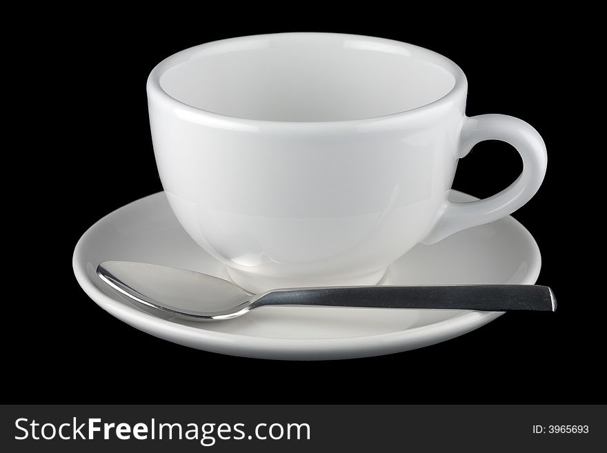 White cup and saucer with spoon, isolated against black background