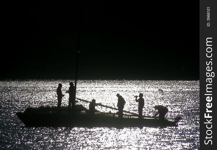 Man in boat on Lecco Lake in Italy backlightin