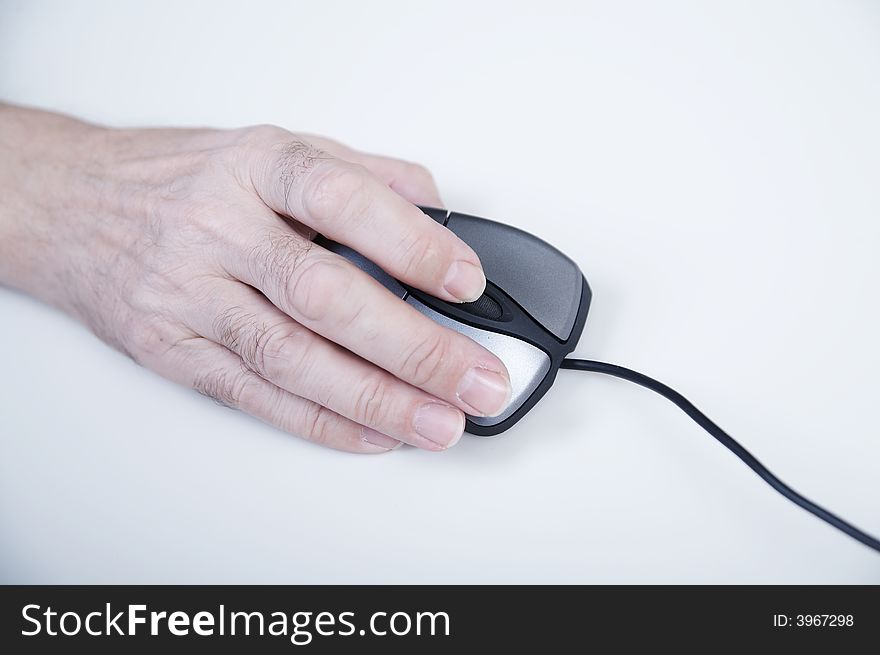 Hand with computer mouse on white table