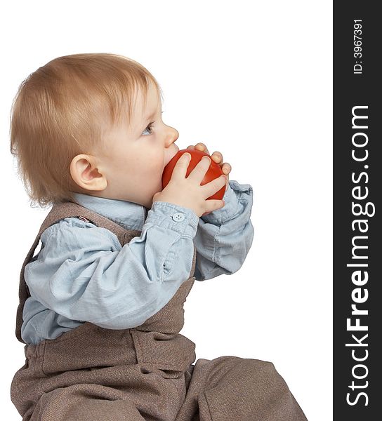 One-year boy eats a tomato. One-year boy eats a tomato.