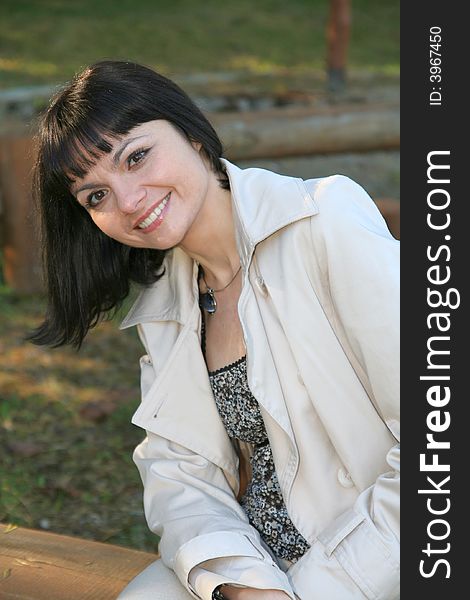 Beautiful woman sitting at the bench in the park. Beautiful woman sitting at the bench in the park