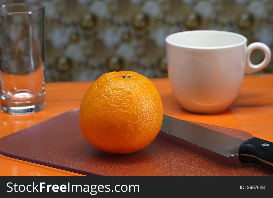 An orange and a cup of coffee for a healthy breakfast