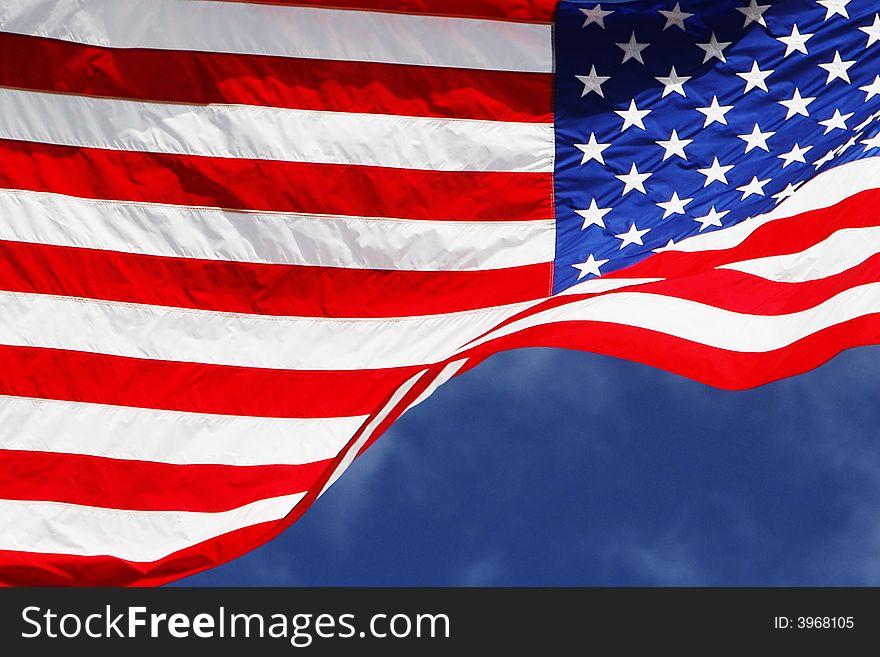 Flowing American flag with blue sky background. Flowing American flag with blue sky background