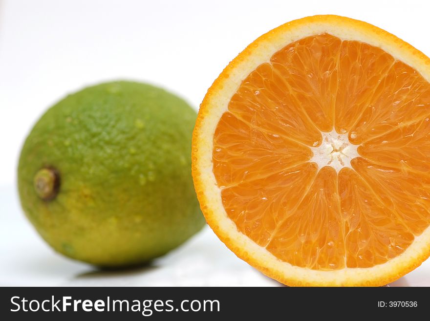 A cut orange, together with a lemon in the background. A cut orange, together with a lemon in the background.