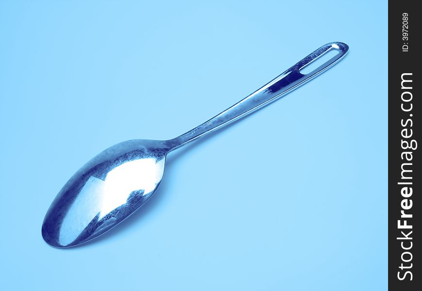One teaspoon on dark blue background, close up