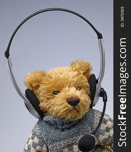 Hildren's toy  bear with  speakerphone on  head on light background, close up