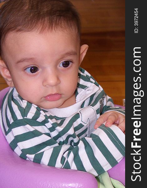 Five month old baby sitting in a baby chair close-up. Five month old baby sitting in a baby chair close-up