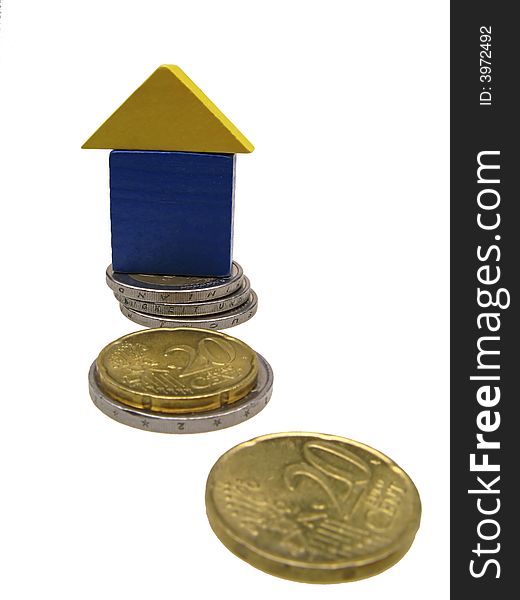 Isolated toy house on coins of euro,  close up