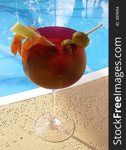 Bloody Mary cocktail by a swimming pool. Bloody Mary cocktail by a swimming pool