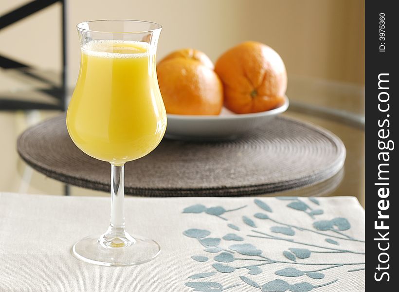 Glass of fresh squeezed orange juice and oranges.