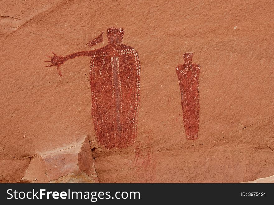 Two ancient Barrier Canyon style pictograph figures on red sandstone in desert southwest. Two ancient Barrier Canyon style pictograph figures on red sandstone in desert southwest