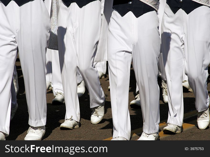 College marching band members legs in unison in Fiesta Bowl parade. College marching band members legs in unison in Fiesta Bowl parade.