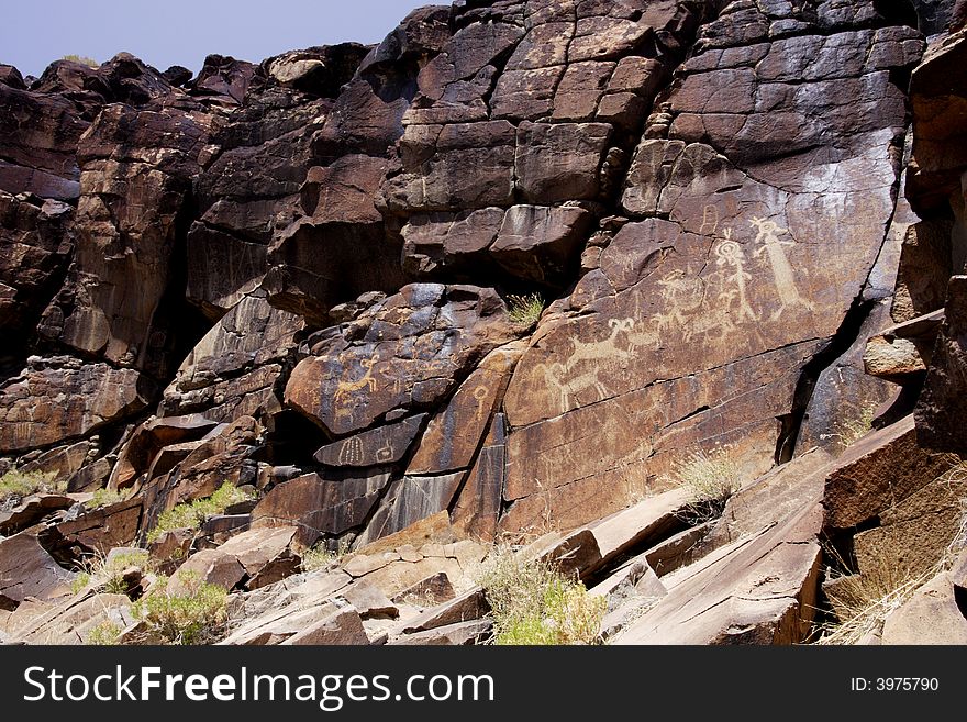 Native American rock art petroglyphs of sheep and anthropomorphic like figures carved into desert varnish covered cliff of Little Petroglyph Canyon in the Coso Range of California. Native American rock art petroglyphs of sheep and anthropomorphic like figures carved into desert varnish covered cliff of Little Petroglyph Canyon in the Coso Range of California