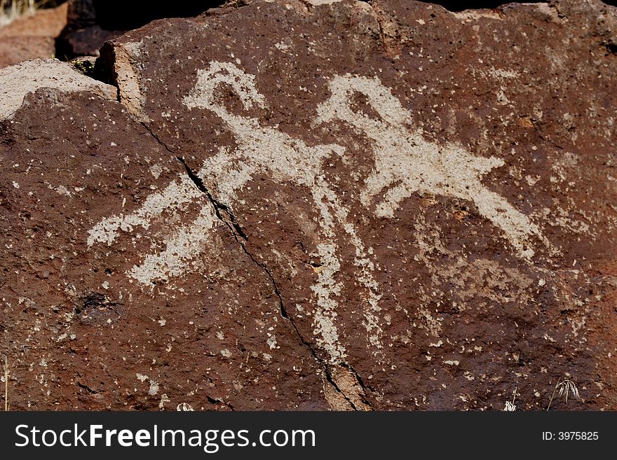 Native American rock art petroglyph close up of two sheep like figures carved into desert varnish covered rock in Little Petroglyph Canyon of the Coso Range in California. Native American rock art petroglyph close up of two sheep like figures carved into desert varnish covered rock in Little Petroglyph Canyon of the Coso Range in California