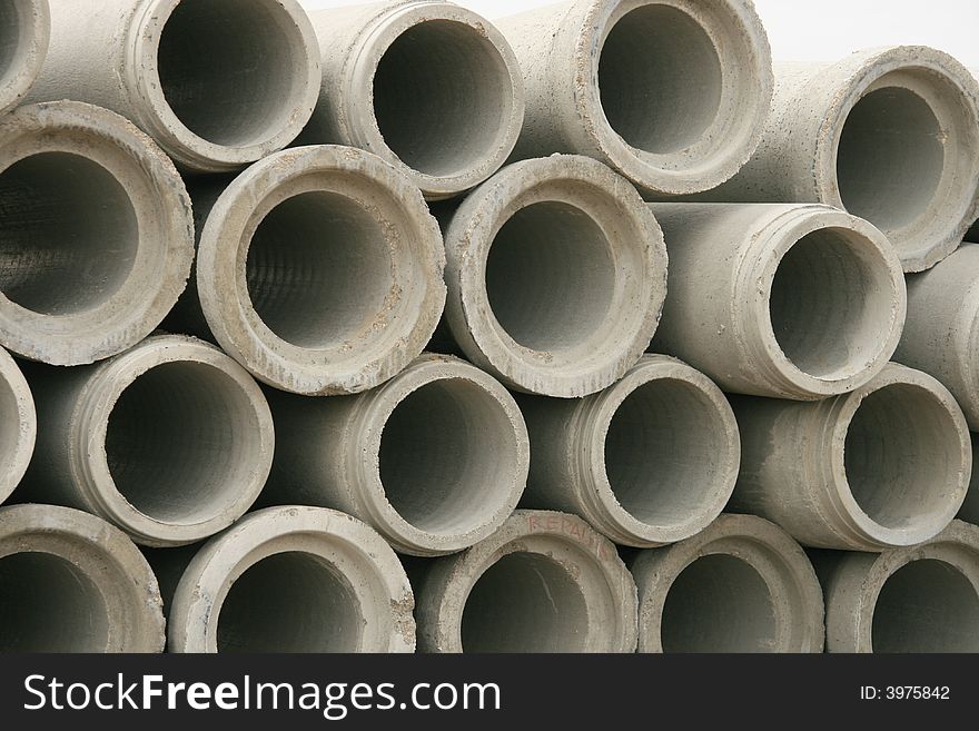 Close up detail of a pile of concrete sewer pipes waiting to be installed. Close up detail of a pile of concrete sewer pipes waiting to be installed