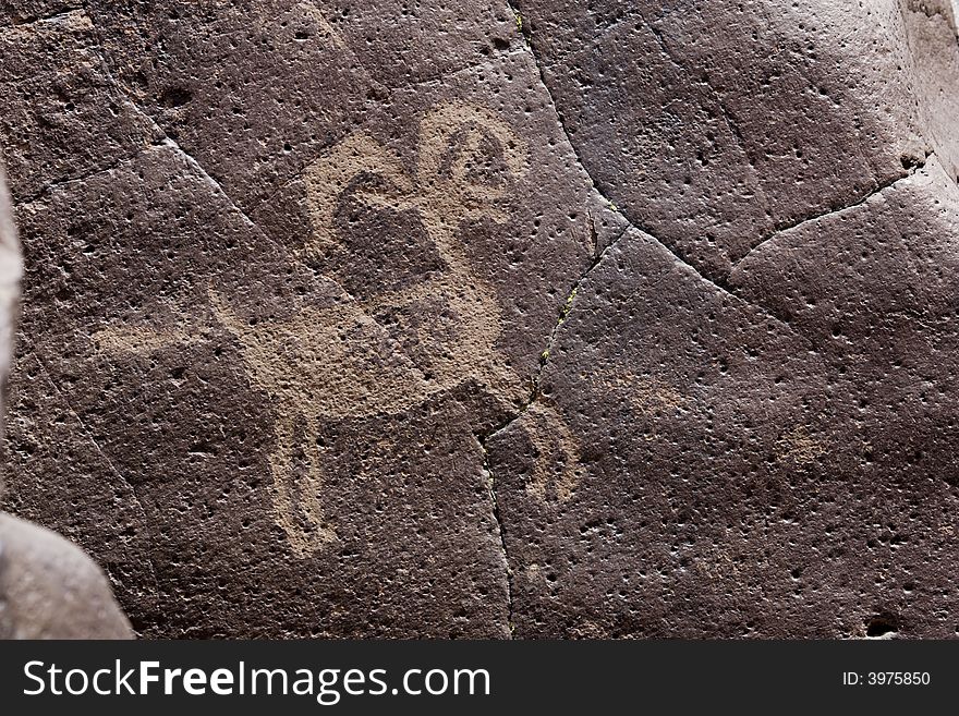 Native American rock art petroglyph close up of sheep like figure carved into desert varnish covered rock in Little Petroglyph Canyon of the Coso Range in California. Native American rock art petroglyph close up of sheep like figure carved into desert varnish covered rock in Little Petroglyph Canyon of the Coso Range in California