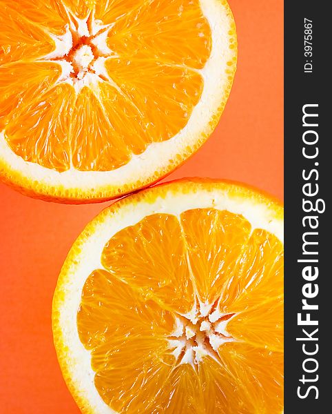Symmetrical vertical photo of two orange slices in opposite corners of frame. Symmetrical vertical photo of two orange slices in opposite corners of frame
