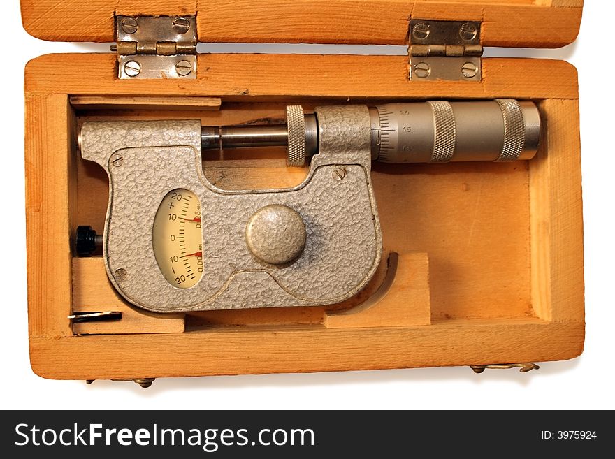 Old micrometer in wooden box isolated