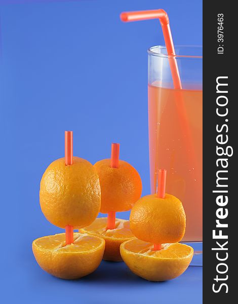 Image from creative series: boats of mandarins and juice on blue background