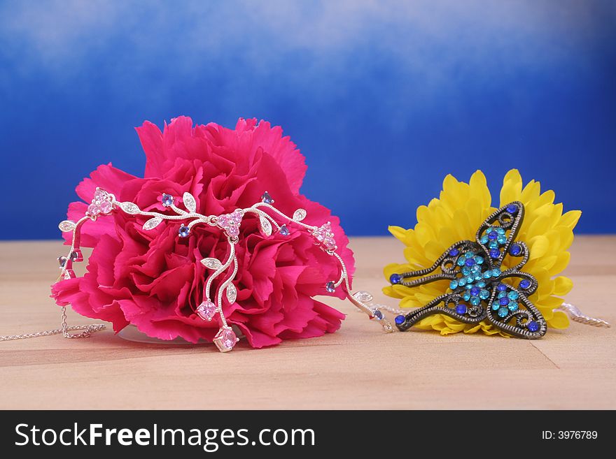 Silver Necklace on Pink Carnation on Blue Background. Silver Necklace on Pink Carnation on Blue Background