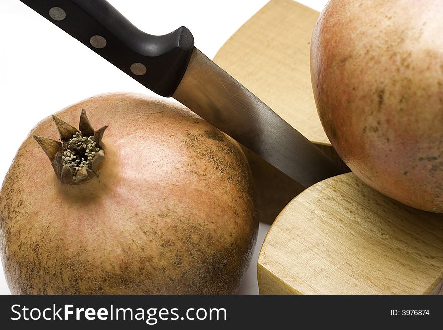 Two juicy pomegranates desserts and a knife. Two juicy pomegranates desserts and a knife