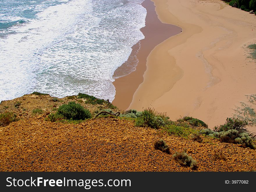 Photo taken looking down a cliff to the sand at the site of the iconic Twelve Apostles coastal rock formation along the Great Ocean Road (Australia). Photo taken looking down a cliff to the sand at the site of the iconic Twelve Apostles coastal rock formation along the Great Ocean Road (Australia).