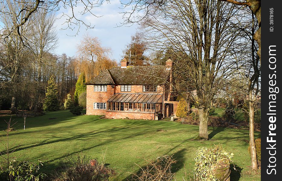 Traditional English Rural House and garden basking in Winter Sunshine