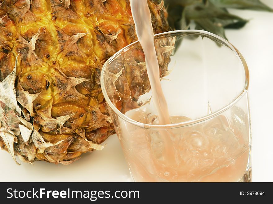 A glass of ice cold juice. Focus is on the top of the glass, background is purposely out of focus