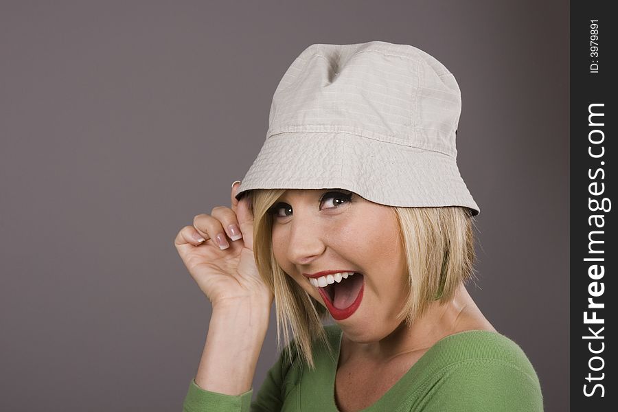 A blonde model with a goofy hat smiling. A blonde model with a goofy hat smiling