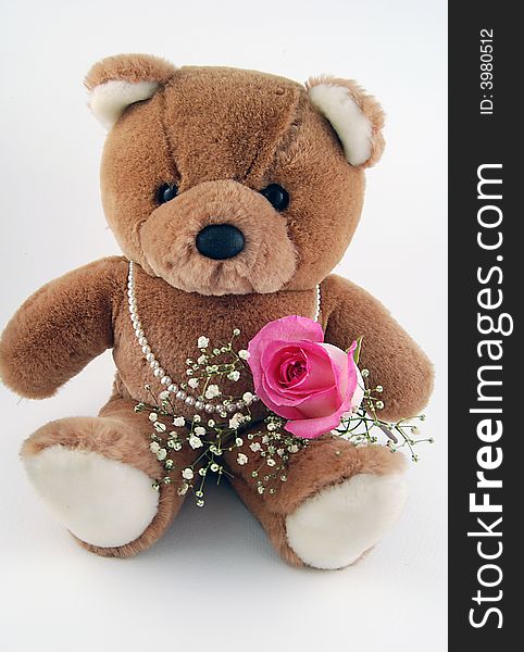 Cute teddy bear holding a rose and wearing a strand of pearls. Cute teddy bear holding a rose and wearing a strand of pearls.