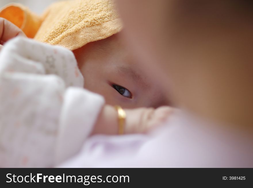 Baby suckling in mother's arms