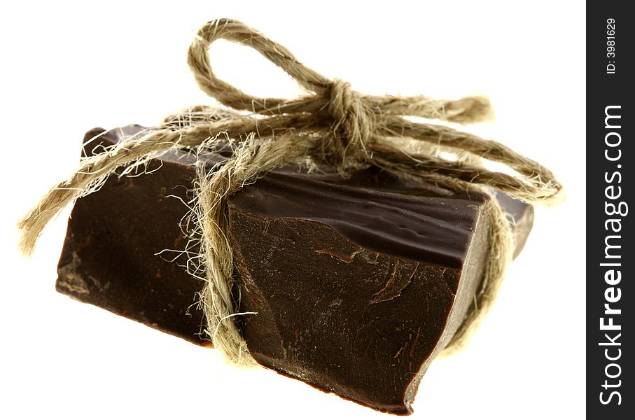 Thick piece of CHOKOLATE tied by rope, soft focus, isolated