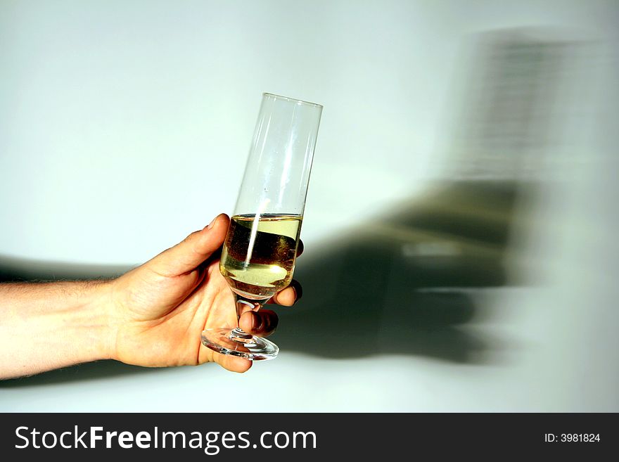 Hand of a man holding a glass of white wine drinking to. on white background, shadow reflected. Italy. Hand of a man holding a glass of white wine drinking to. on white background, shadow reflected. Italy
